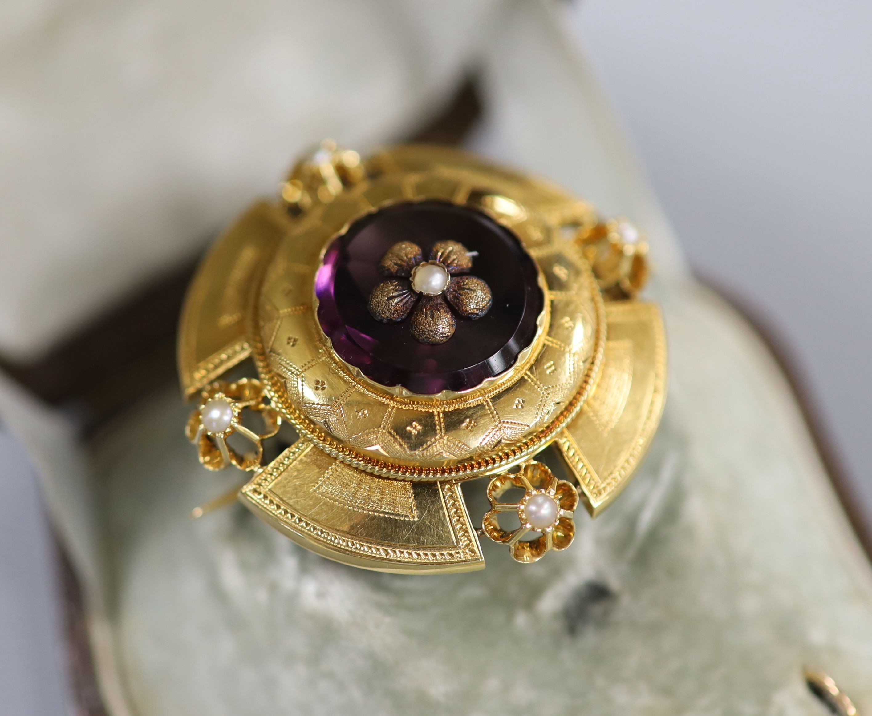 A cased continental Victorian style yellow metal, amethyst paste and seed pearl set demi parure, comprising a brooch and pair of matching earrings, brooch 35mm, earrings overall 37mm, gross weight 12.8 grams.